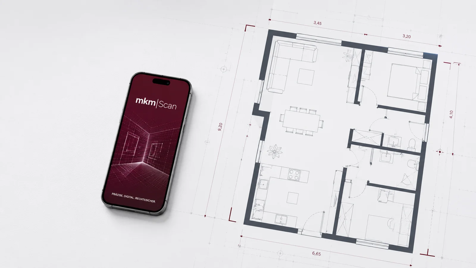 Smartphone mit mkm|Scan App neben einem bemaßten Grundriss auf Blaupausen-Papier